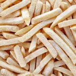 Frozen french fries background, top view
